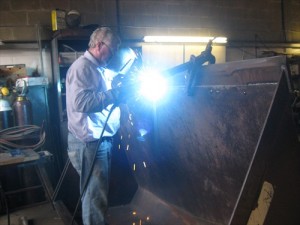 Welding a new cutting edge on to a loading bucket